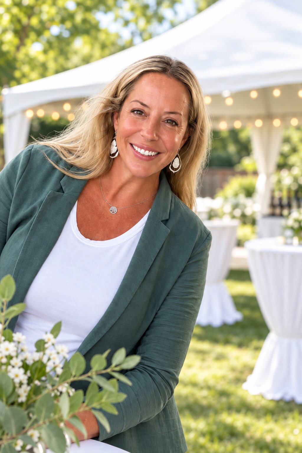 Jessie, owner of Neighborly Party Rentals, smiling in front of an outdoor party tent