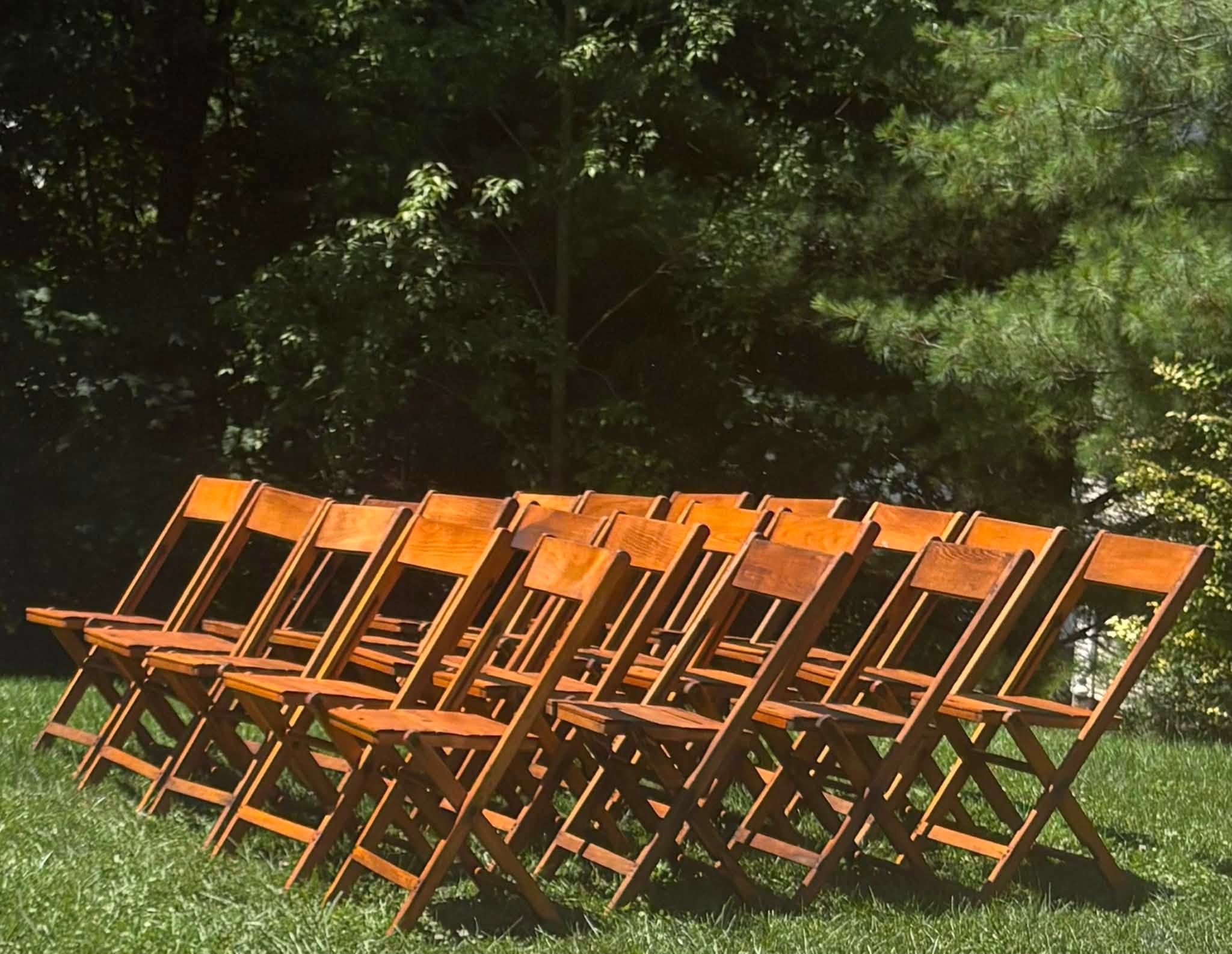 Rows of stained wooden folding chairs outdoors